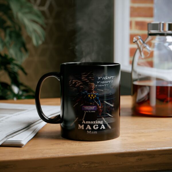 Amazing MAGA Man Mug Black Ceramic sitting on a table next to a tea pot