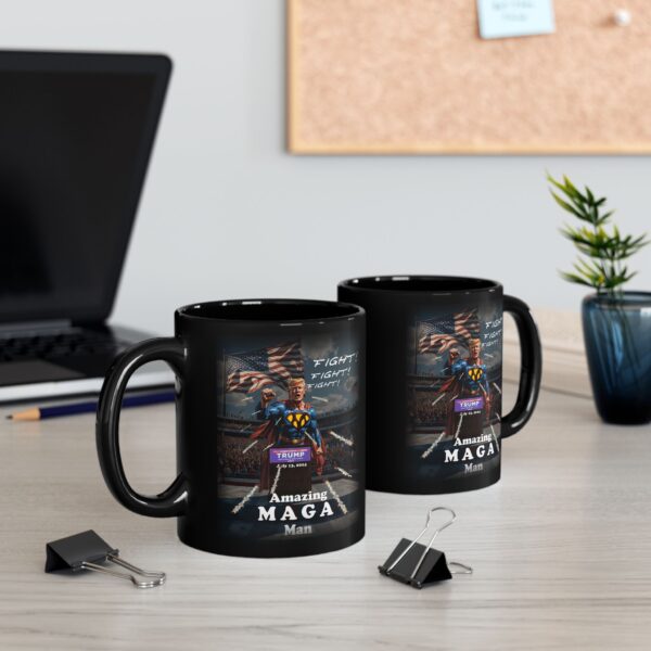 Two Amazing MAGA Man Mugs Black Ceramic next to a laptop