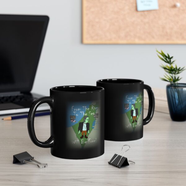 Two Black Frankenstien Will Be Free Ceramic Mugs next to a laptop