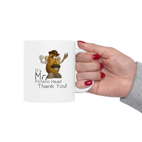 mr. potato head mug being held by a women with red finger nails