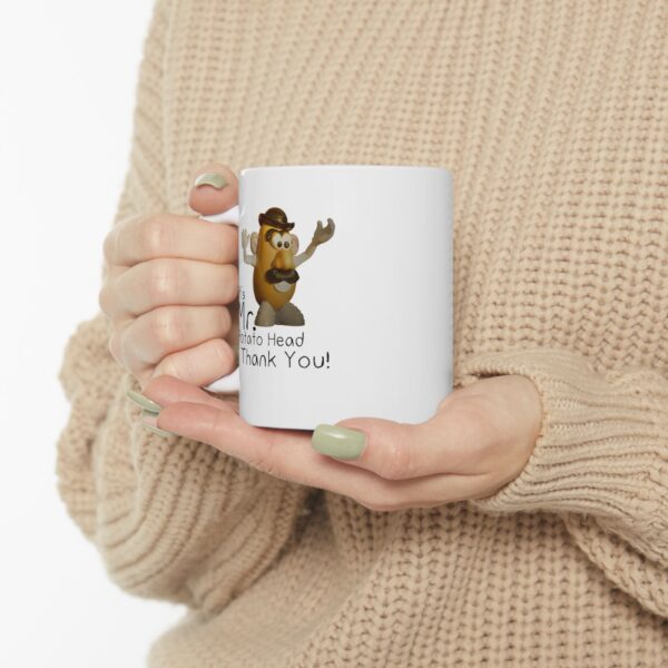 mr. potato head mug being held by a women wearing a beige colored sweater