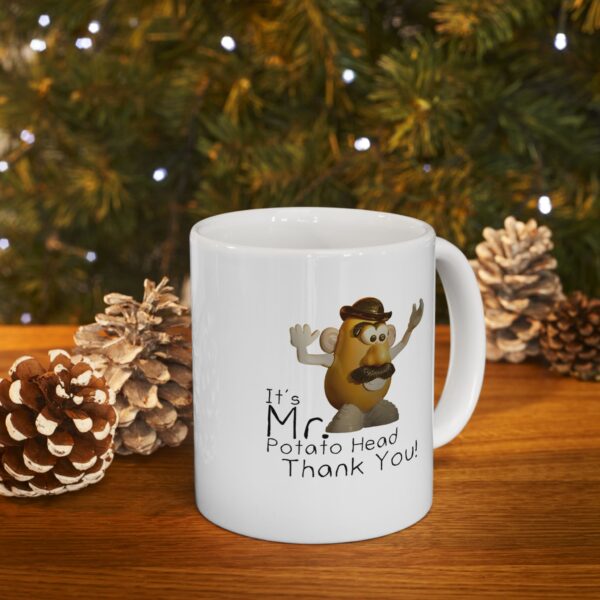 mr. potato head mug sitting on a table in front of pinecones