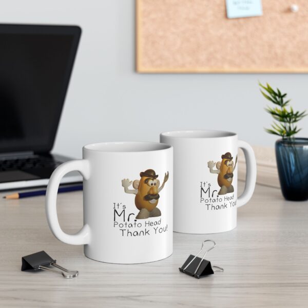 two mr. potato head mugs on a table in front of a laptop computer