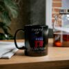 Party Of Projection black ceramic mug with white text on table next to tea pot