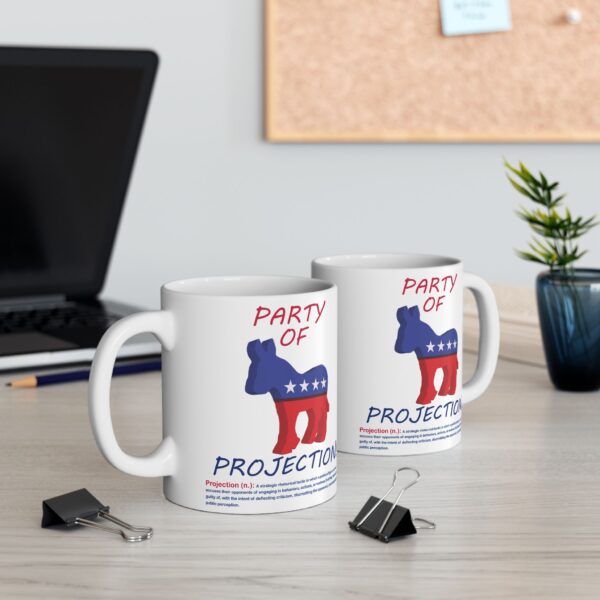 Two Party Of Projection white ceramic mugs on a table next to a laptop